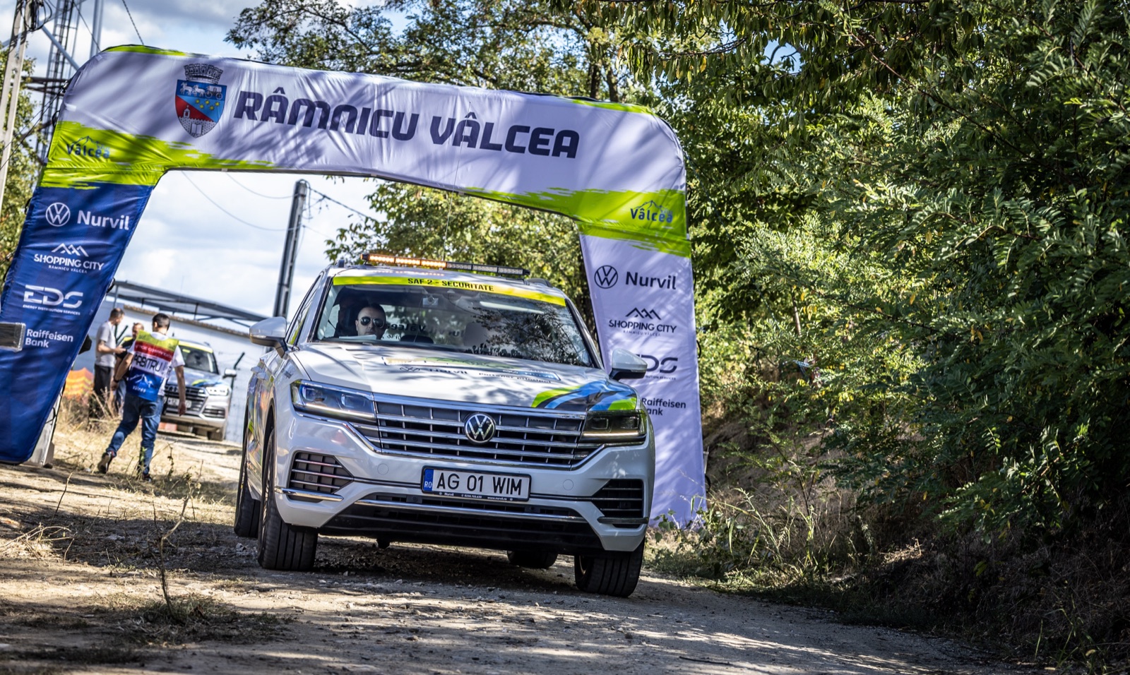 Volkswagen Touareg alb, mașina de securitate SAF 2, sub arcada Râmnicu Vâlcea la Raliul Vâlcii 2026
